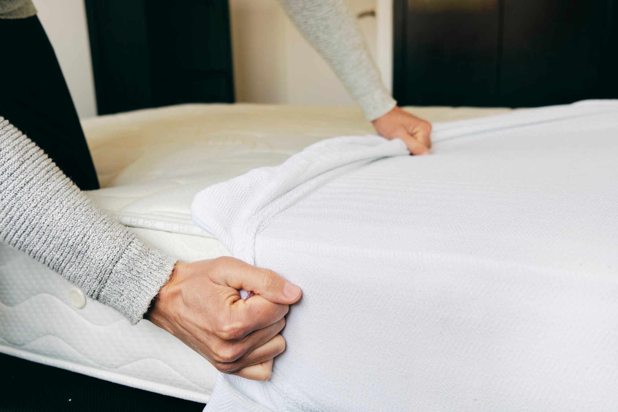 Man putting on mattress protector